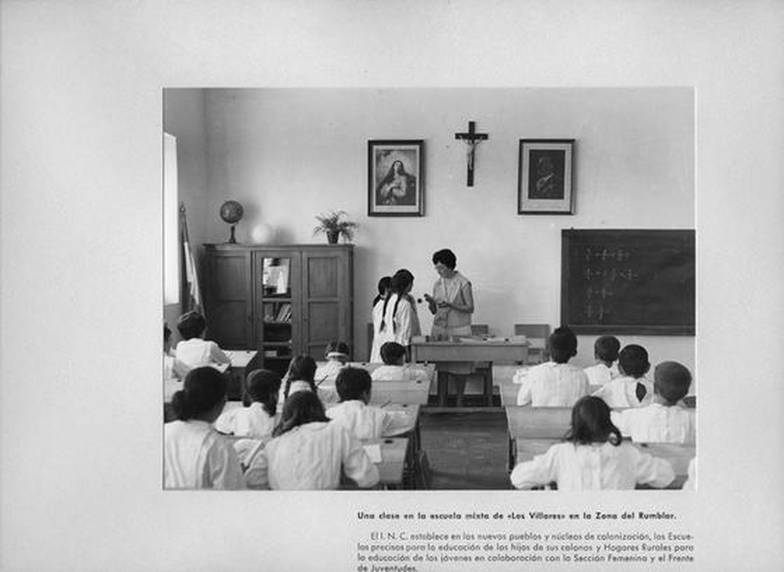 Imagen de una escuela a la que asistían los niños de los poblados de colonización con la simbología religiosa y el retrato de Franco en el frontal.