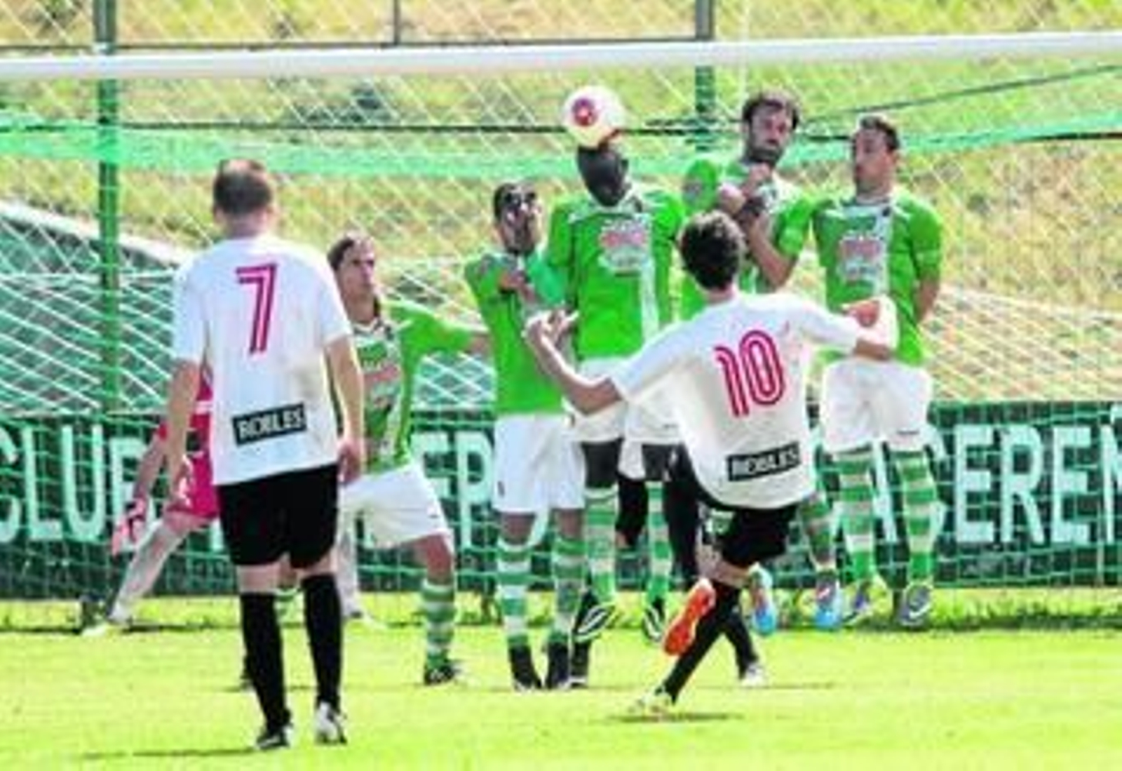 Carlos Fernández lanza una falta directa que la barrera intenta despejar saltando.