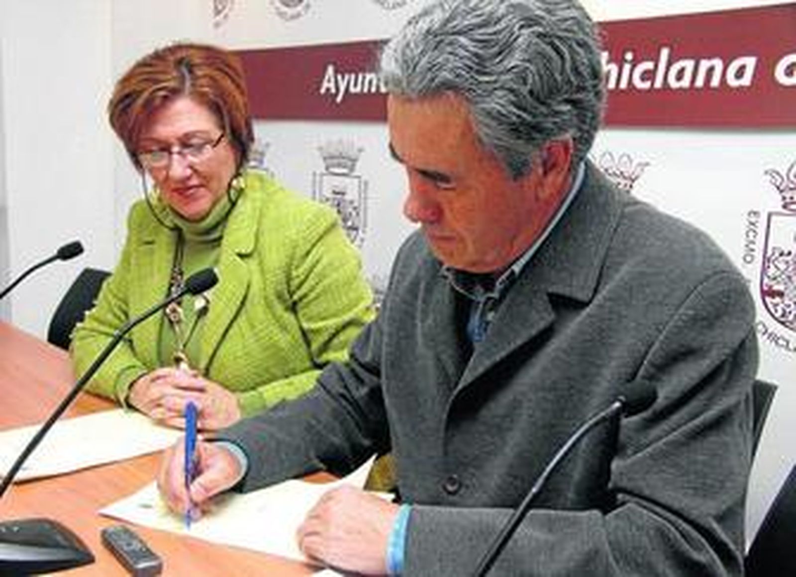 Rafael Real, gestor de cooperativas, firma el convenio en presencia de la delegada de Vivienda.