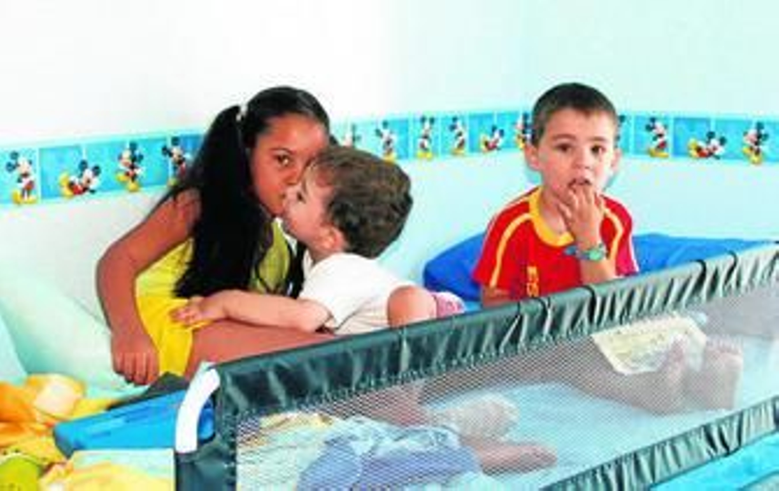 Varios niños en la cama antes de dormir.