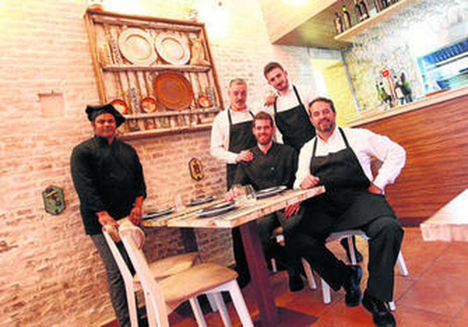 Miguel Jiménez y Javier Mecías, gerente y chef del Juanillo Madriguera, respaldados por parte del equipo del restaurante.