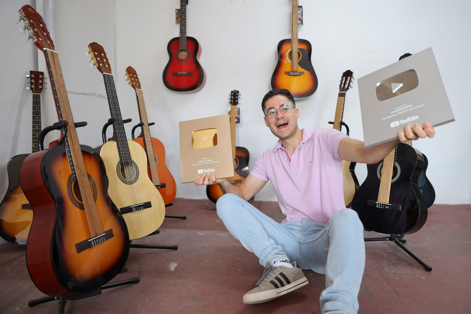 Adrián Campos posa para 'Málaga Hoy' con las guitarras que regala y unas placas de YouTube