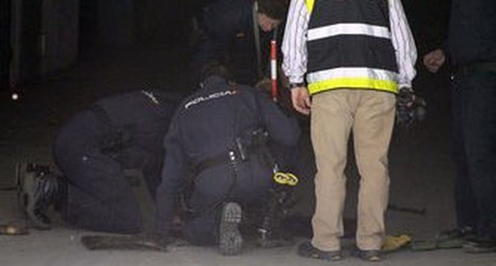 Varios agentes buscan el arma homicida en una alcantarilla. / EFE