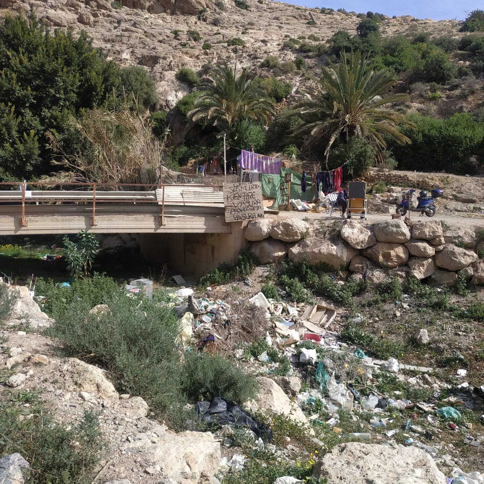 Cartel protesta de una persona sin hogar por el vertido de basuras