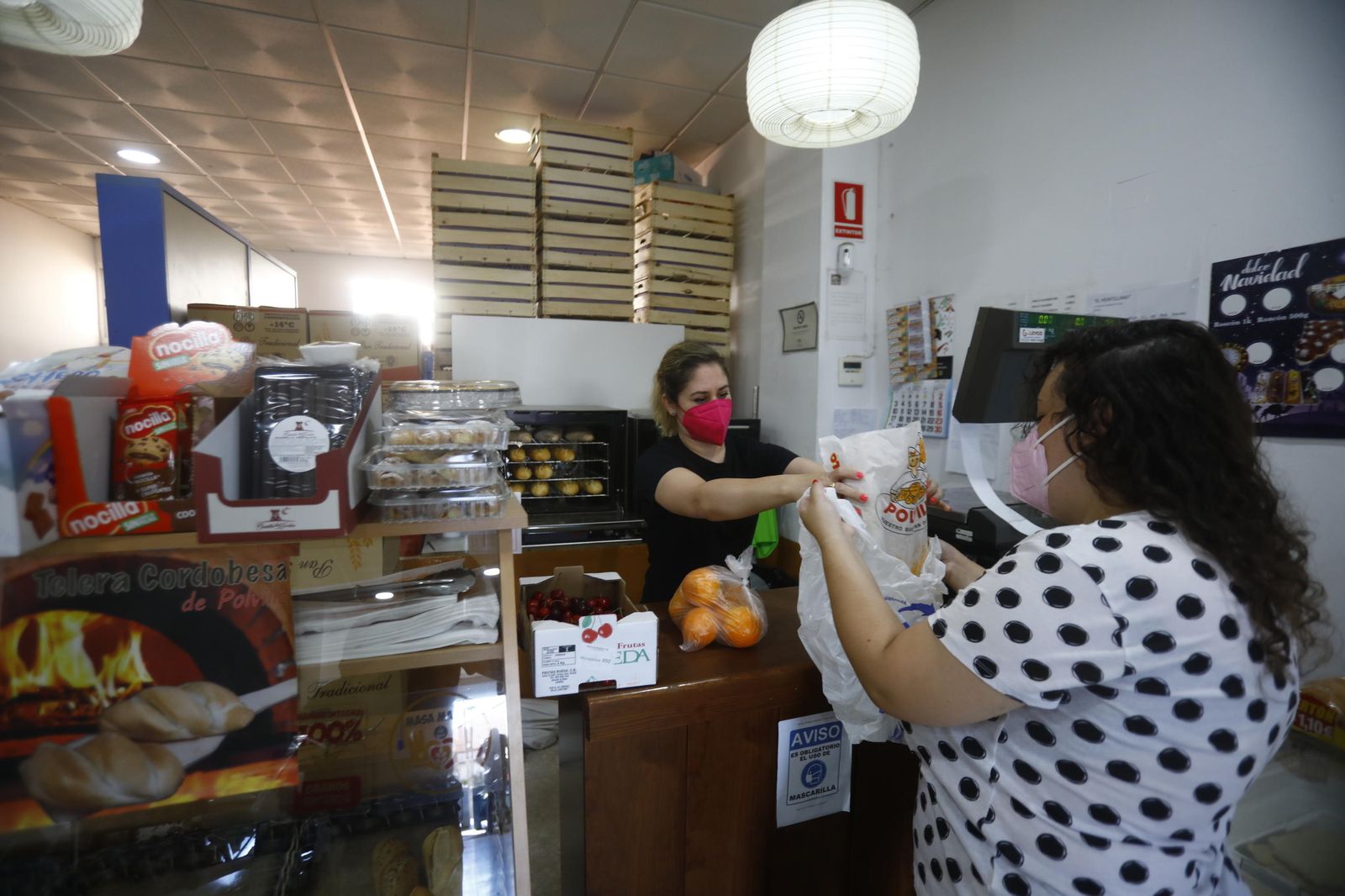 Una dependienta atiende a una mujer en su tienda.