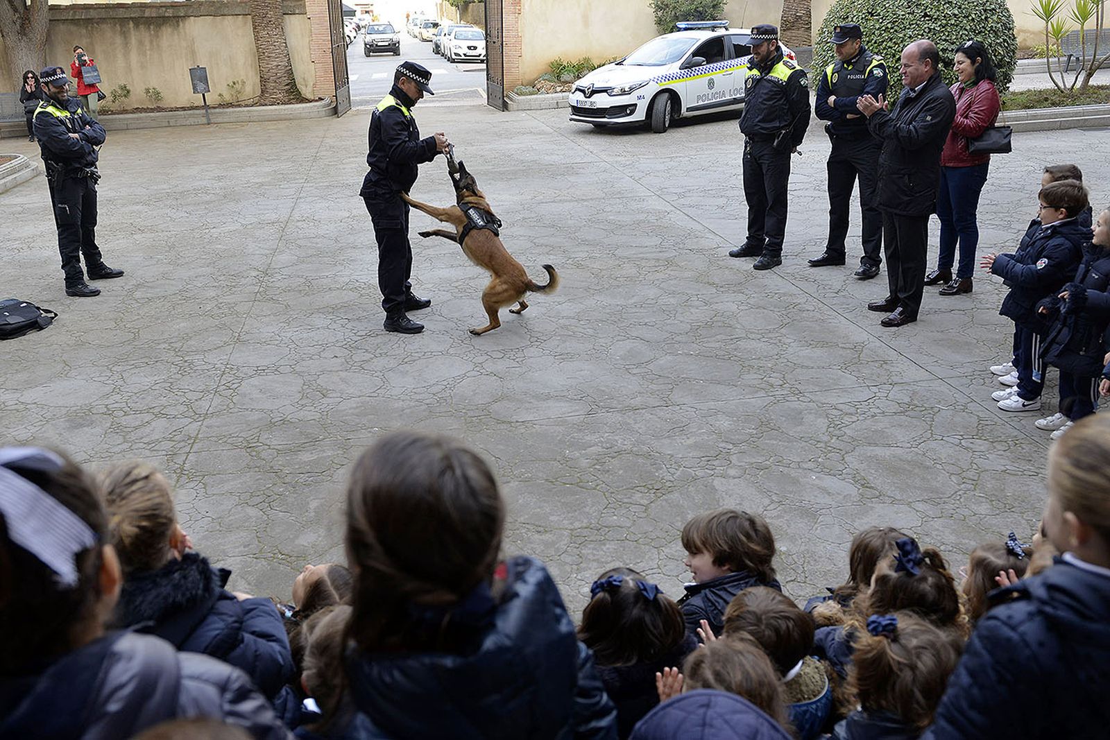 Los alumnos observan a 'Rusell' realizar varios ejercicios con un agente de la Policía Local.