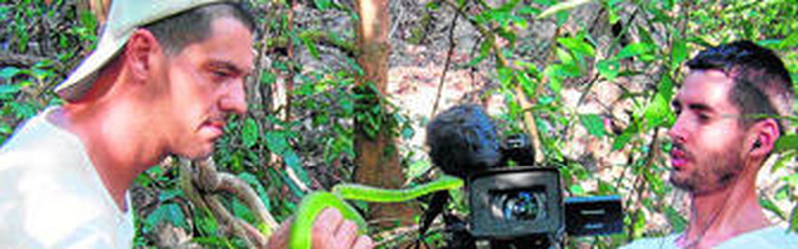 Frank Cuesta muestra un ejemplar de serpiente al operador de cámara Santiago Trancho.