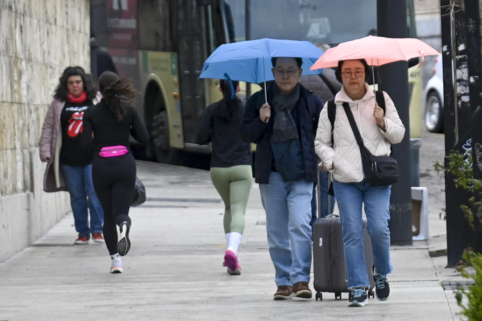 Dos turistas se protegen de la lluvia de este fin de semana en la capital.