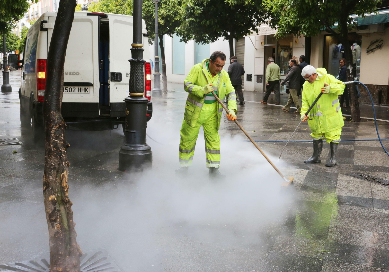 Dos trabajadores de Urbaser limpiando la calle Larga.