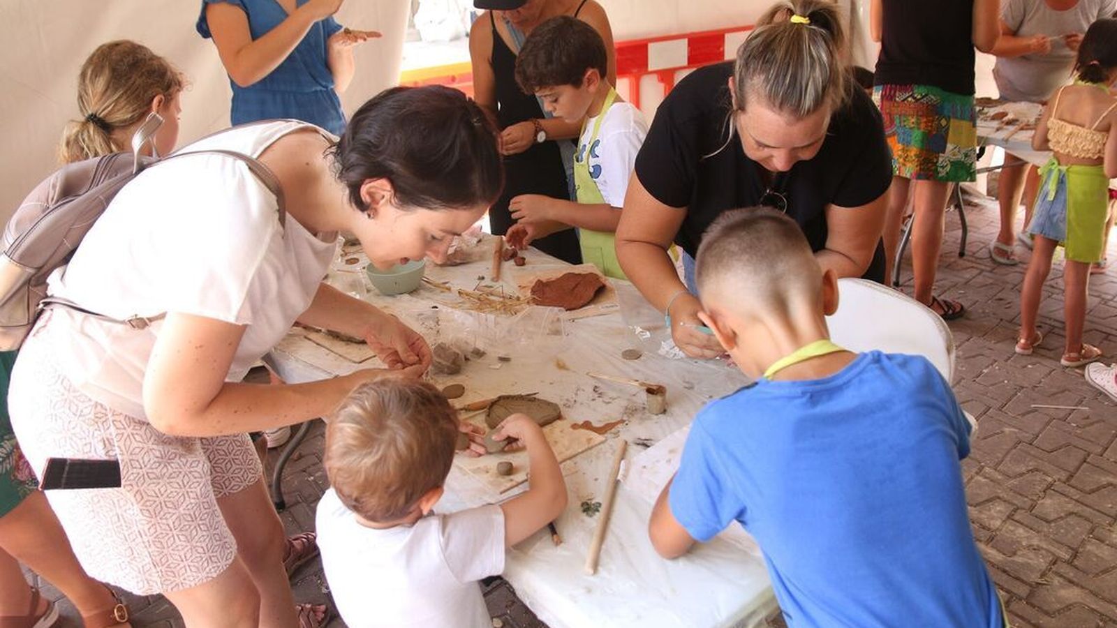 Padres y madres, involucrados con sus hijos en los talleres infantiles de alfarería.