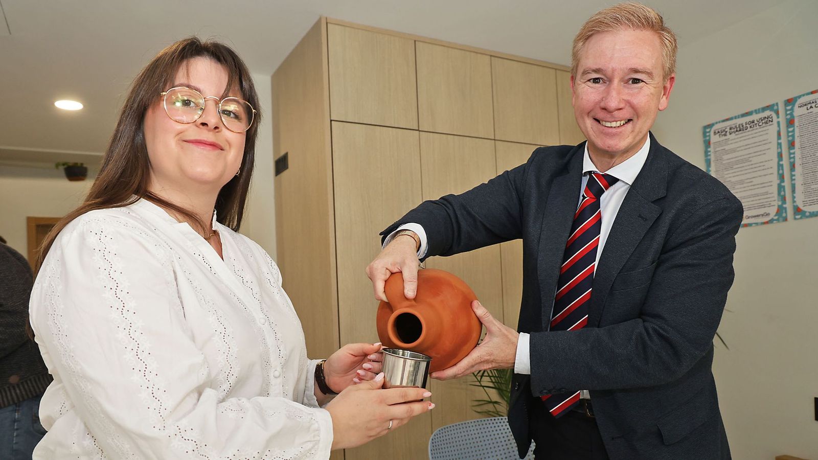 Alfonso Castro alivia la sed de Laura Yáñez durante el distendido momento de la Tertulia Cofrade El Aguaó
