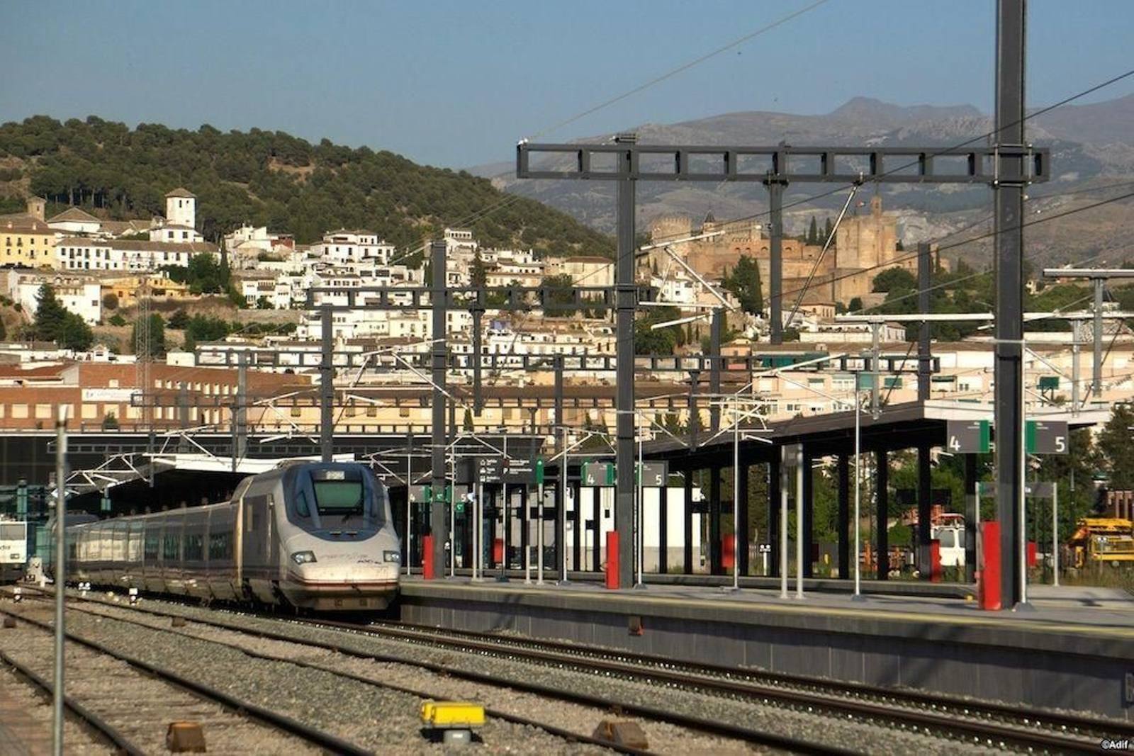 Un tren AVE en la estación de Granada, con la Alhambra de fondo