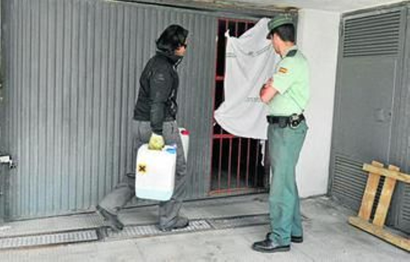 Un guardia civil y un investigador, junto a la puerta del garaje en la que quedó aprisionado Tondo.