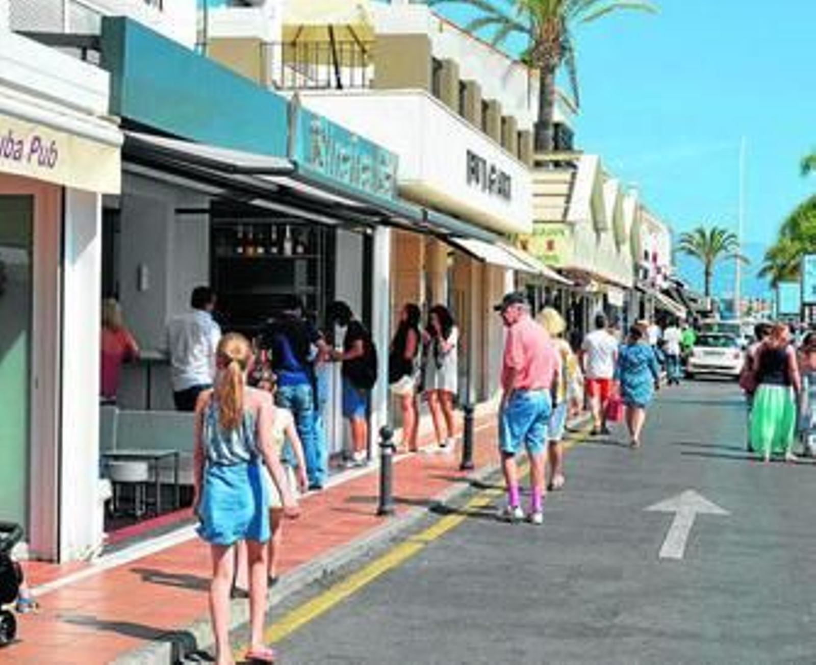 Turistas pasean por Puerto Banús.