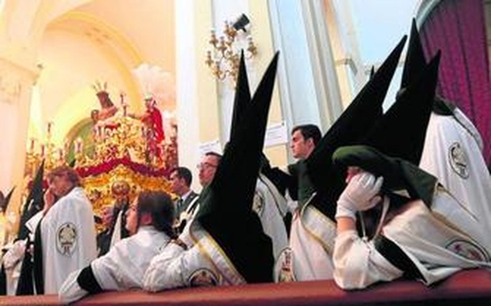 Varios nazarenos en el interior de San Andrés.