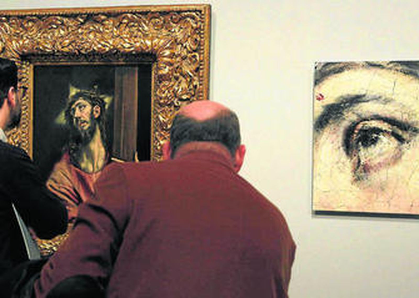 Visitantes observan el cuadro 'Cristo abrazado a la Cruz' junto a detalles de su estudio técnico.