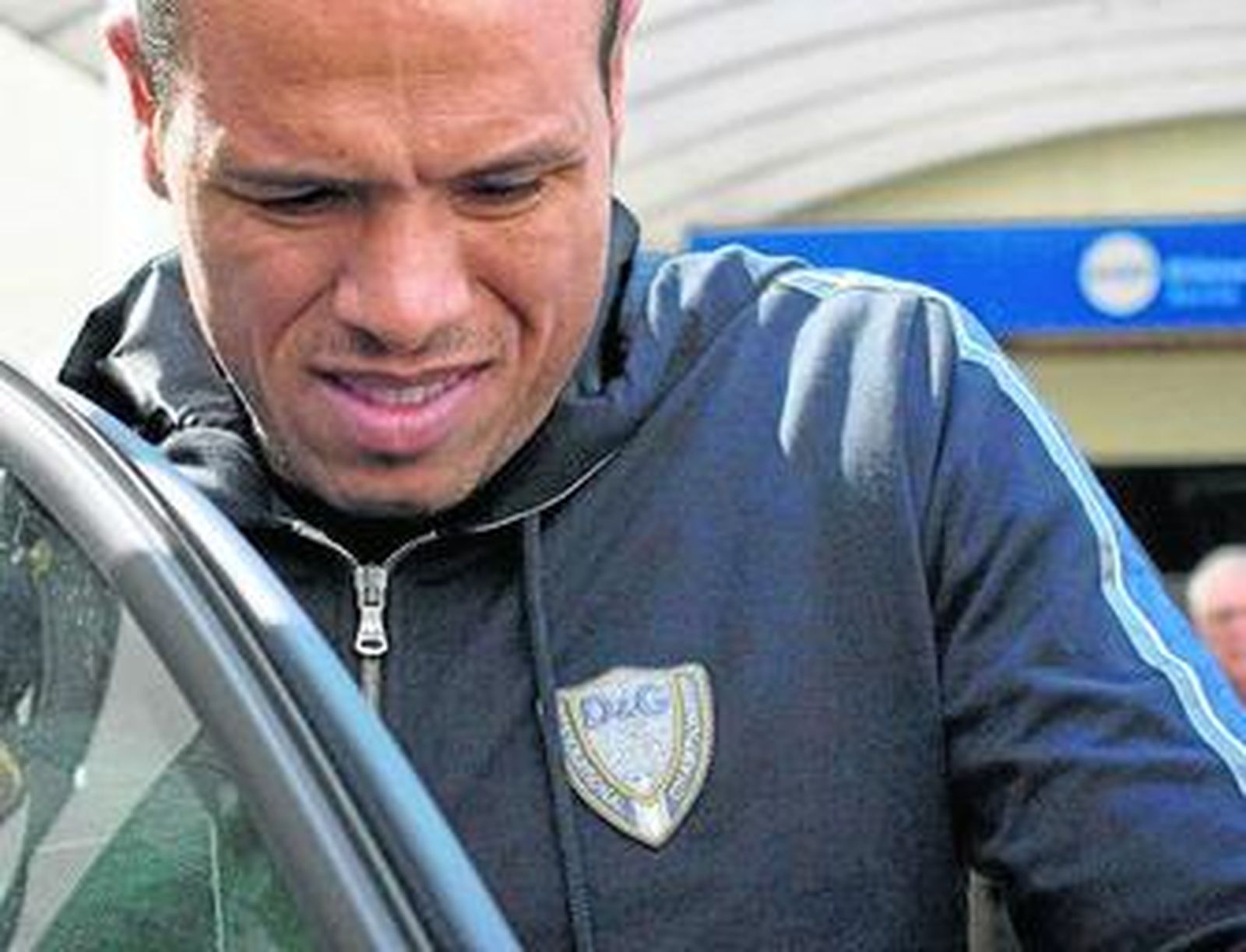 Luis Fabiano, con un gesto de dolor, se introduce con trabajo en un vehículo al salir de la clínica donde fue revisado.
