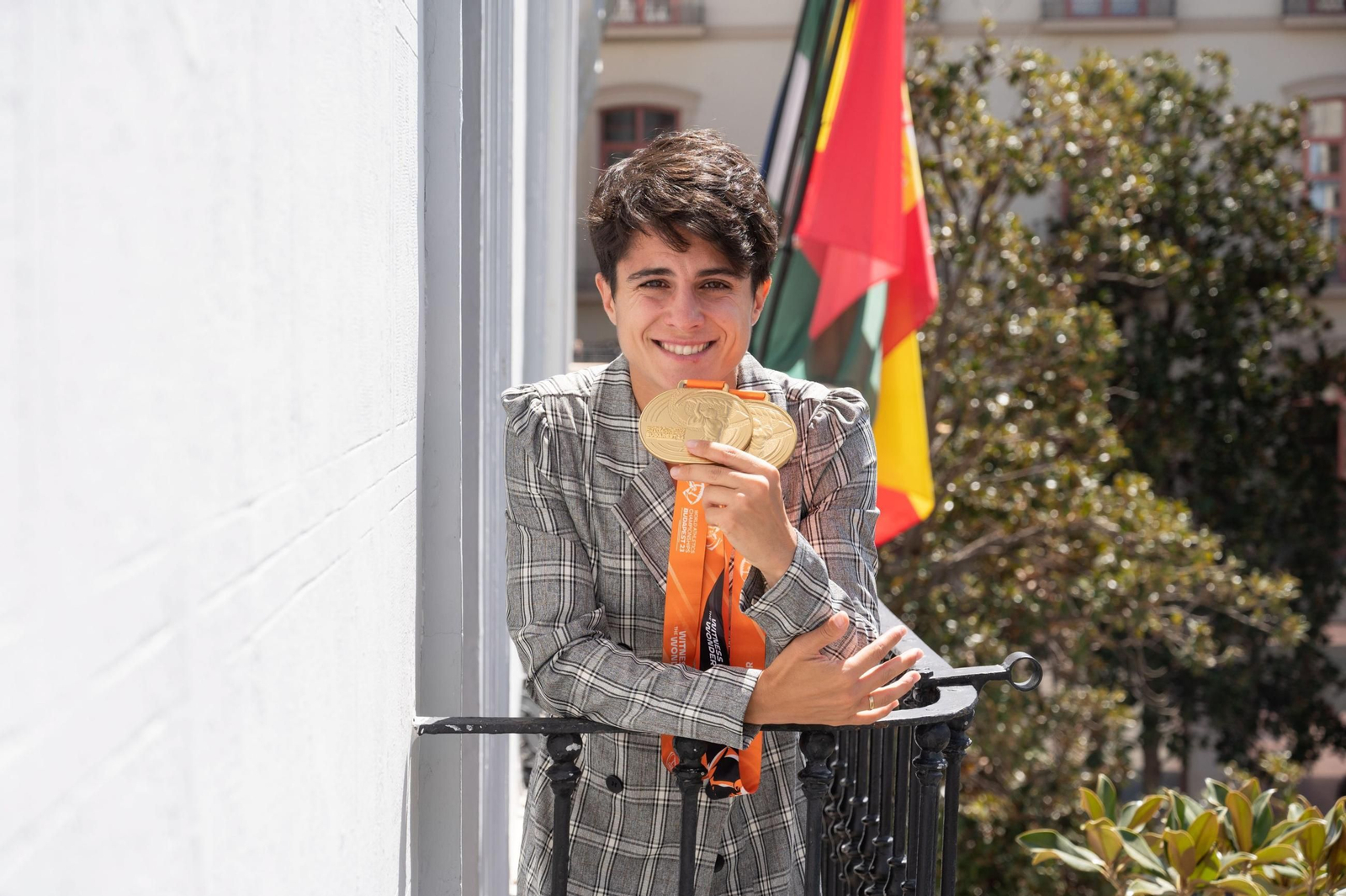 La marchadora María Pérez, desde el balcón del Ayuntamiento de Granada, mostrando sus medallas de campeona del mundo