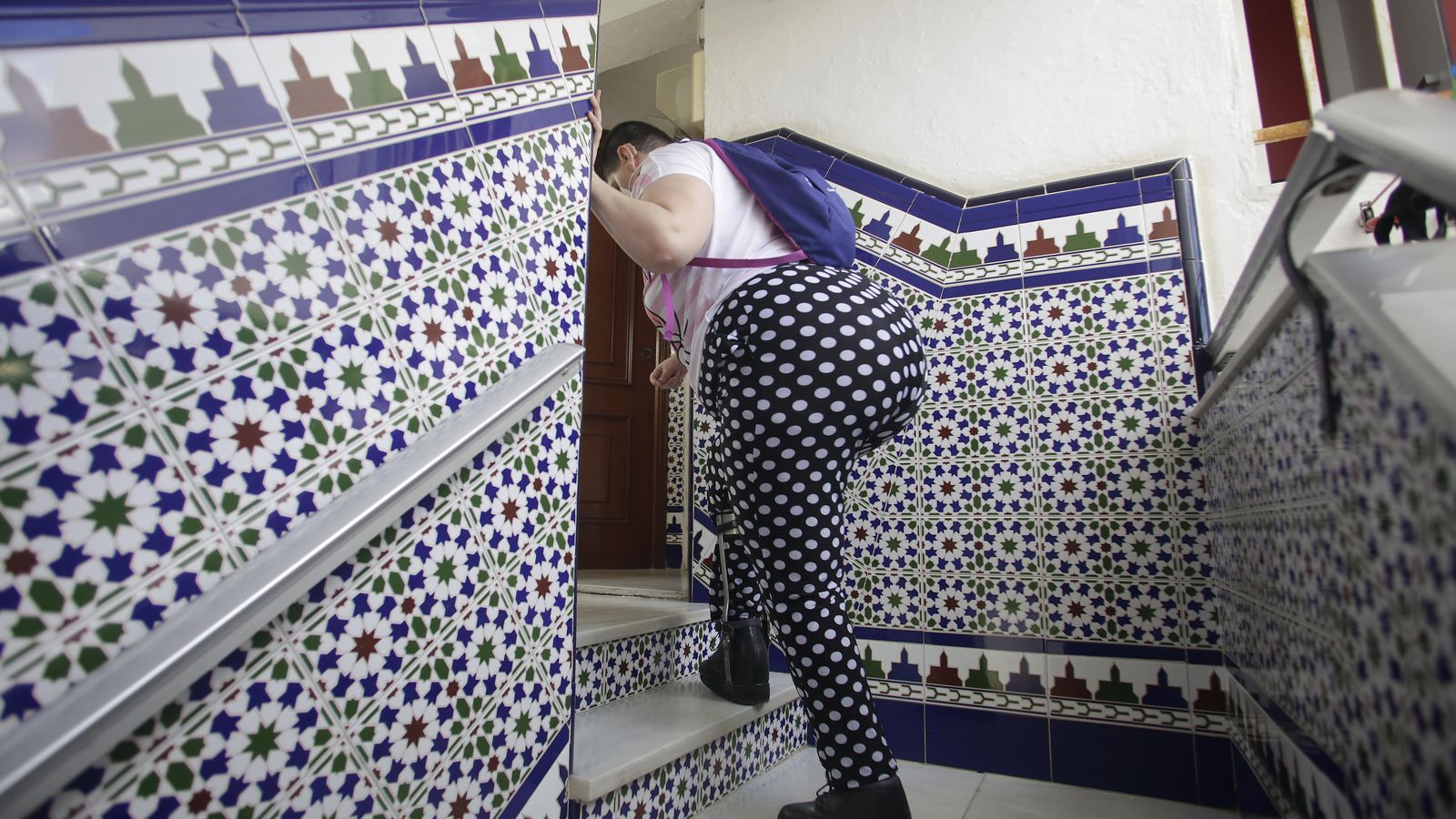 Marina tarda lo indecible para subir los escalones hasta su casa.