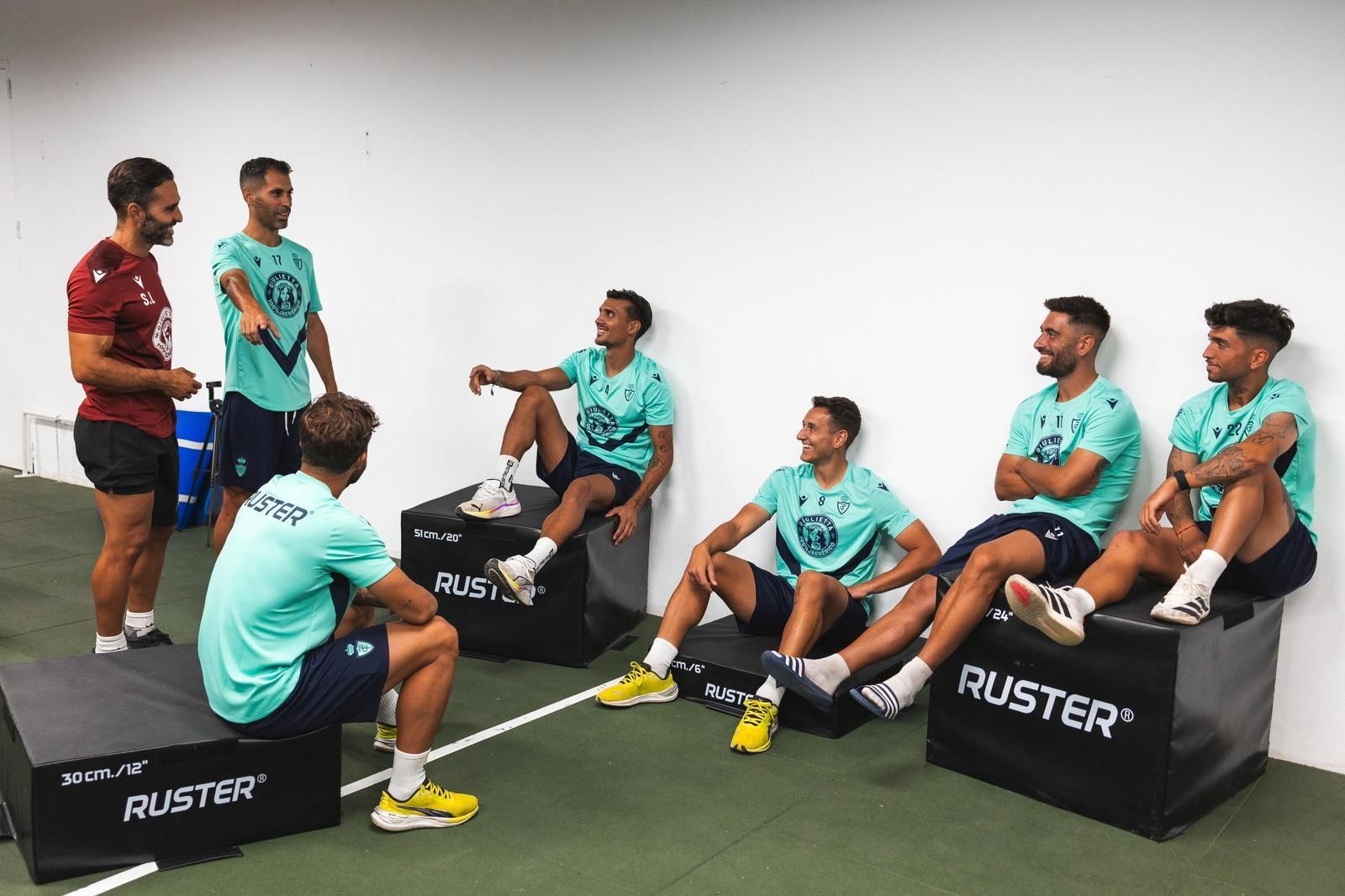 Varios jugadores del Real Jaén charlan con Santi López en el reformado gimnasio de La Victoria.