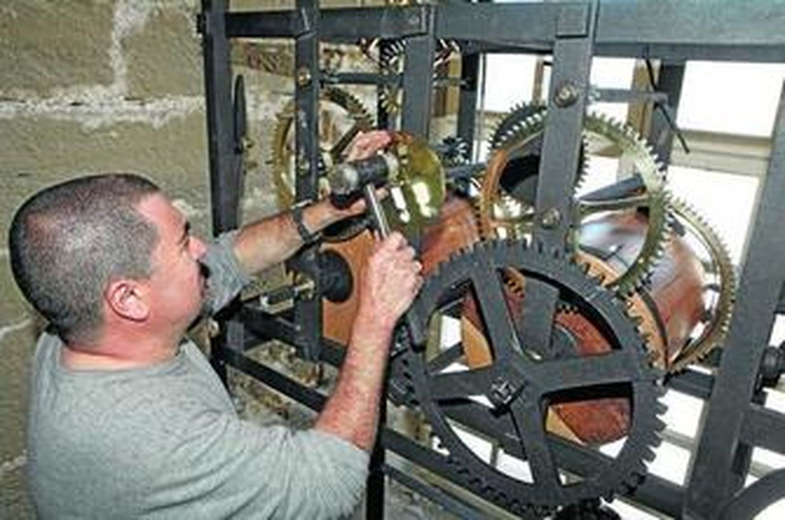 Un operario de la UCA termina de montar el mecanismo original del reloj de la Catedral, que ha sido restaurado.