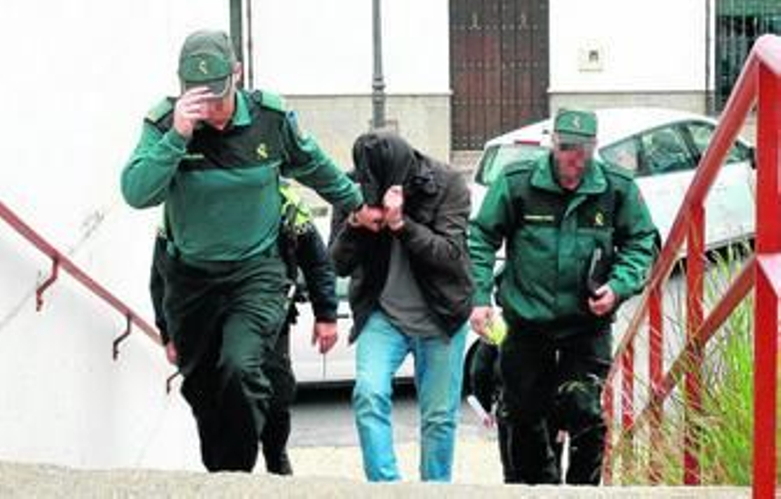 Ramallo, ocultando su rostro bajo una capucha y custodiado por los agentes del Instituto Armado, a su llegada a los juzgados de Aracena en la mañana de ayer.