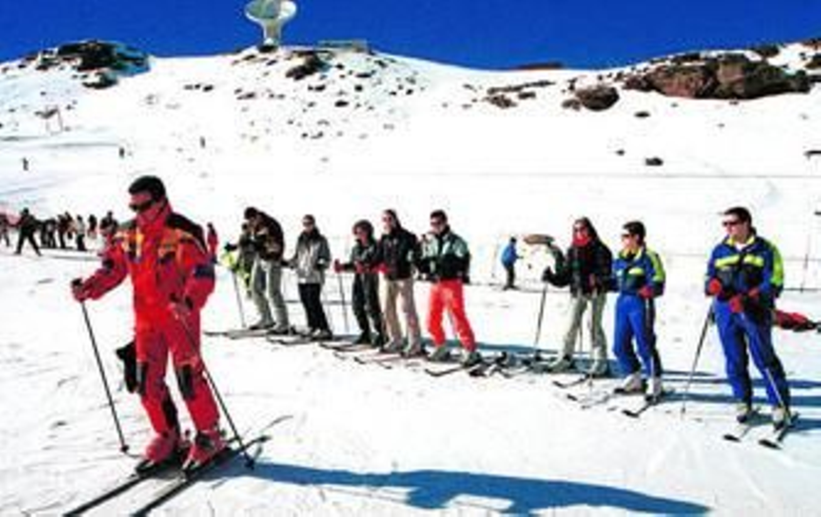 Un monitor enseña a un grupo de jóvenes técnicas de esquí en Sierra Nevada.