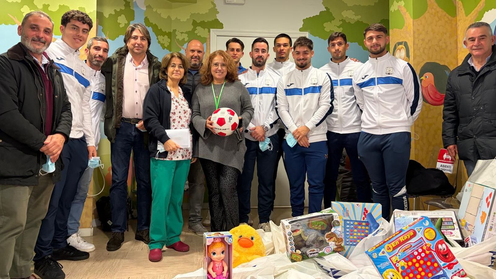 Foto de familia de la visita del Jerez Industrial al Hospital para entregar juguetes a los pequeños ingresados.
