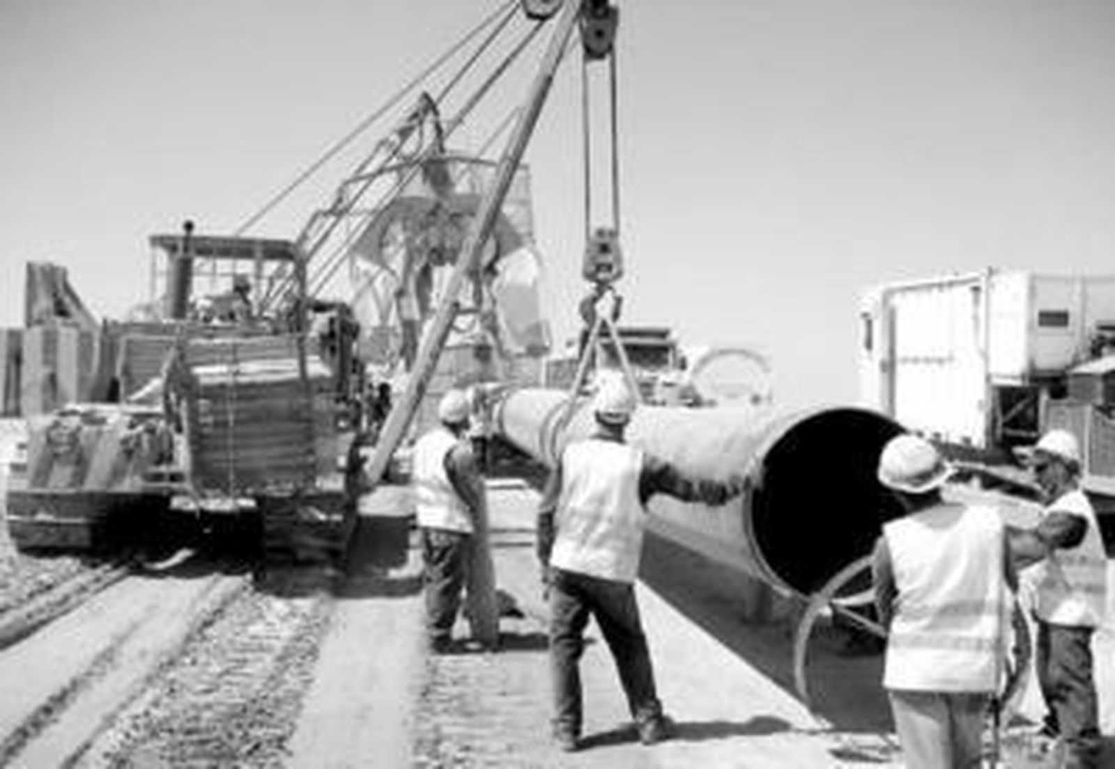 Varios operarios descargan los tubos del gasoducto terrestre que instalará Enagás en Almería.