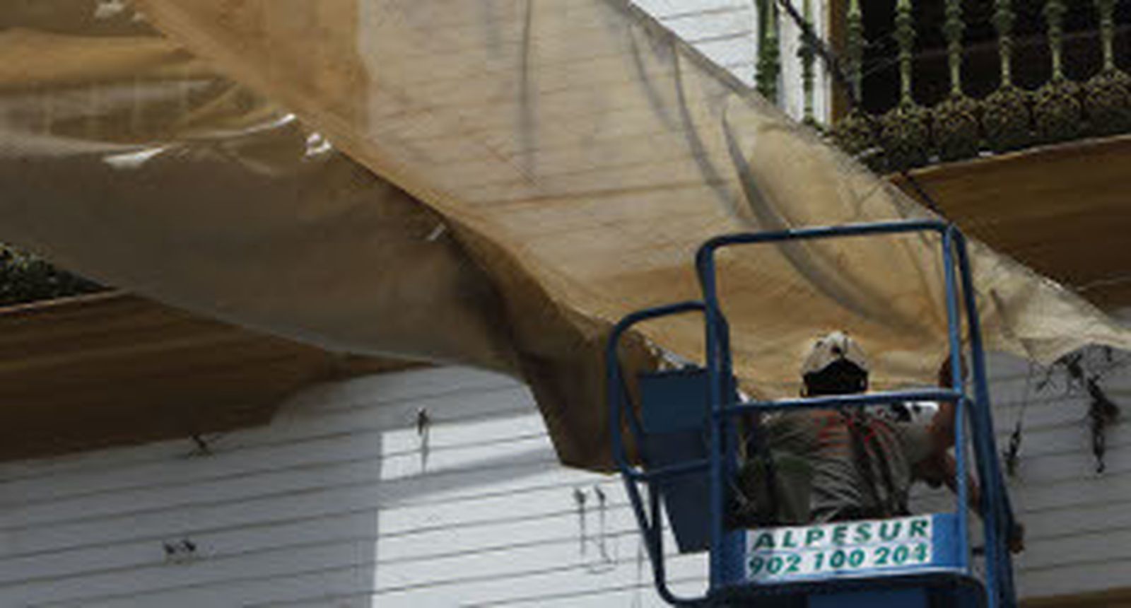 Un operario coloca un toldo. / José Ángel García  Foto: EFE