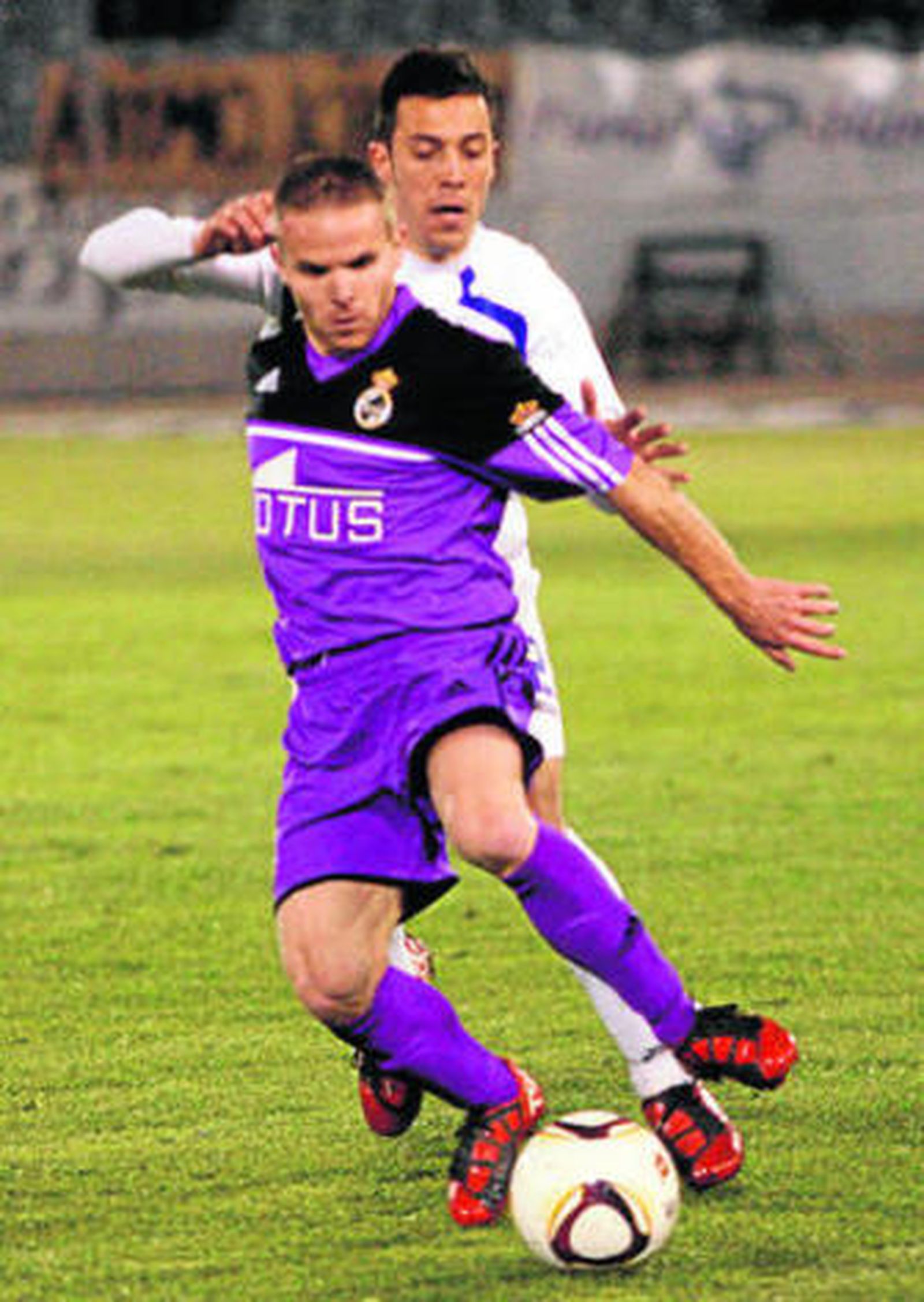 Juampe cubre el balón presionado por un jugador del Jaén.