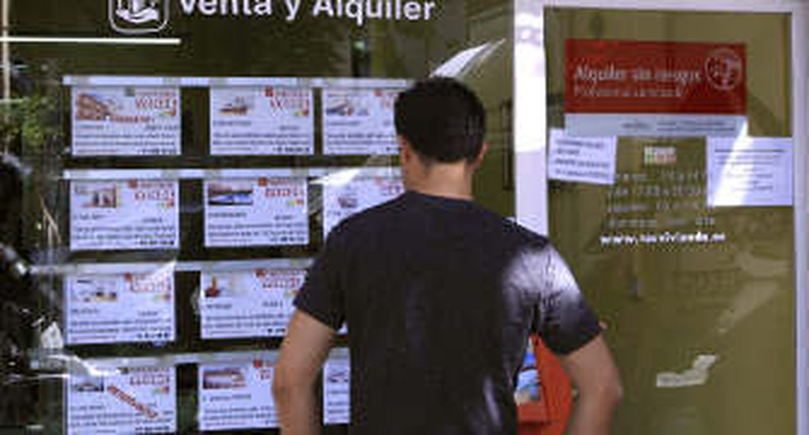 Un joven mira las ofertas de una inmobiliaria.