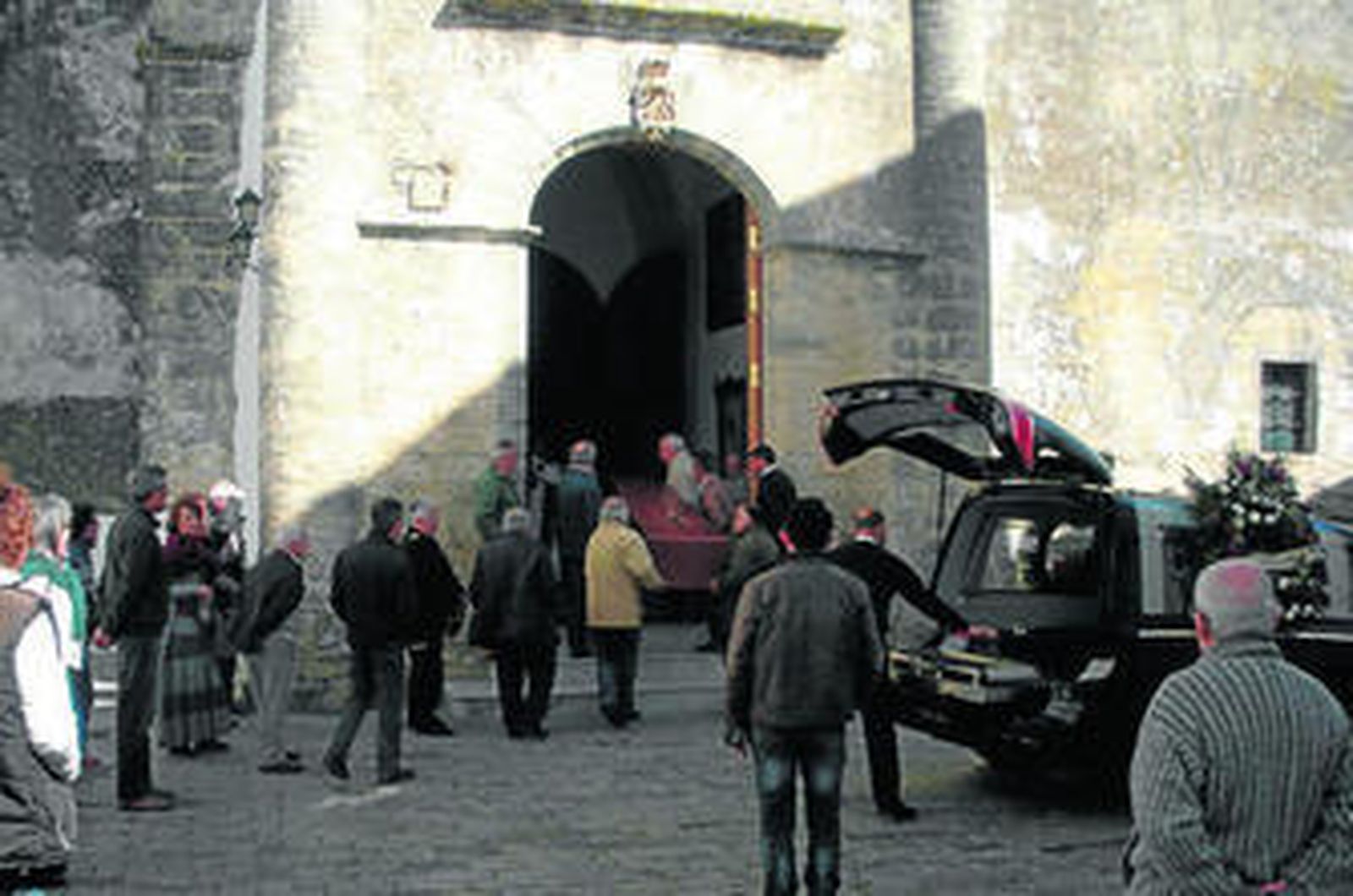 Varios vecinos de Vejer trasladan el féretro al interior de la parroquia.