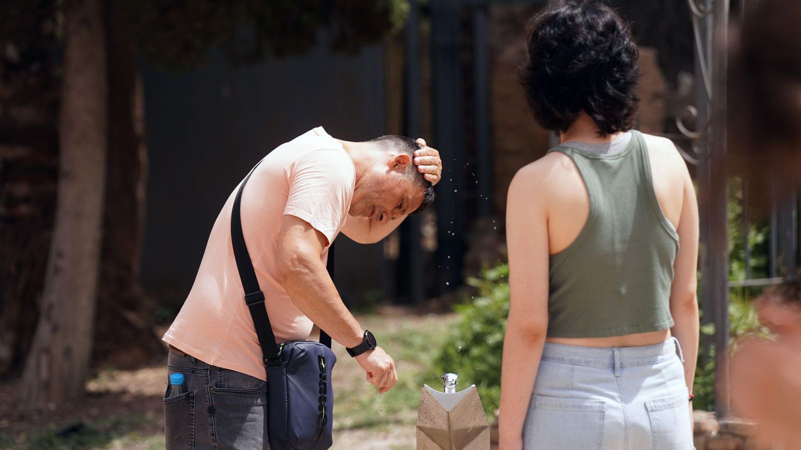 Una pareja se refresca en una fuente en Málaga capital. Una pareja se refresca en una fuente en Málaga capital.