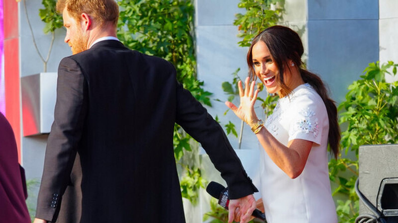 Meghan saluda a un seguidor de la mano de su esposo, el príncipe Enrique.
