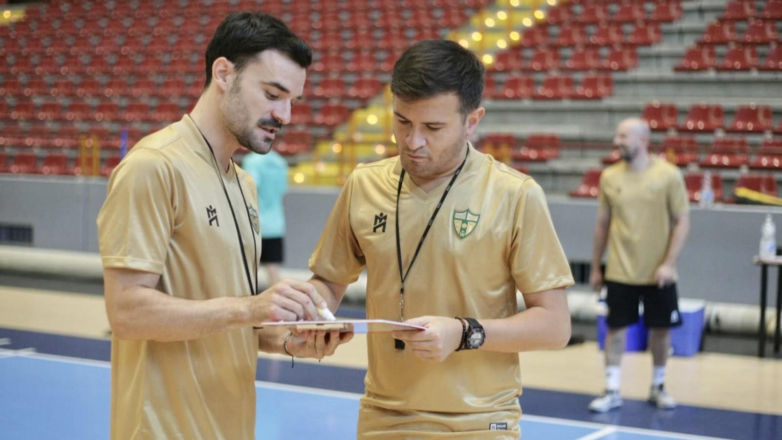 Emanuel Santoro, pizarra en mano, traza una jugada con uno de sus ayudantes.