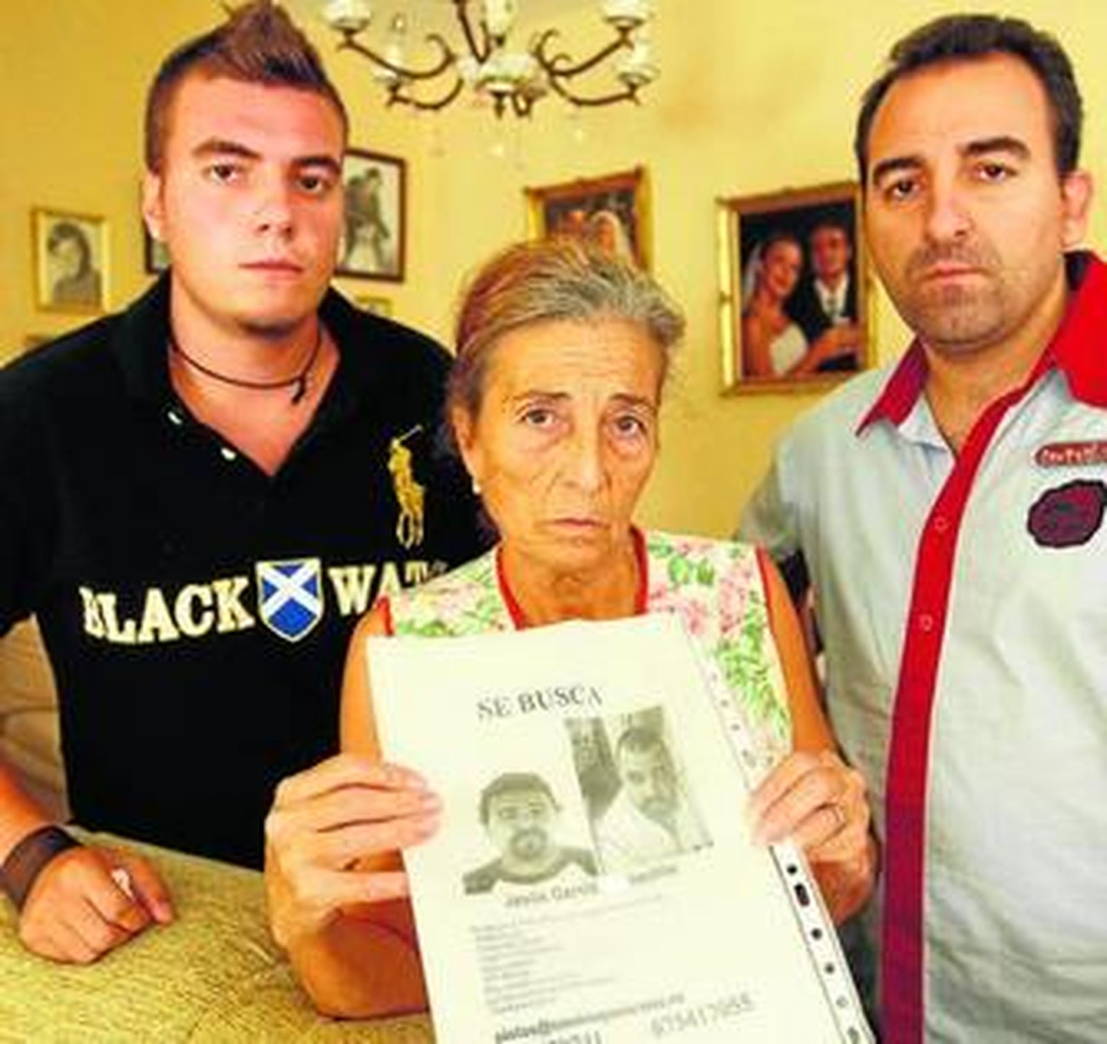 Adan y Javier García, hermanos de Jesús, junto a su madre, Aurora, con una foto del desaparecido.