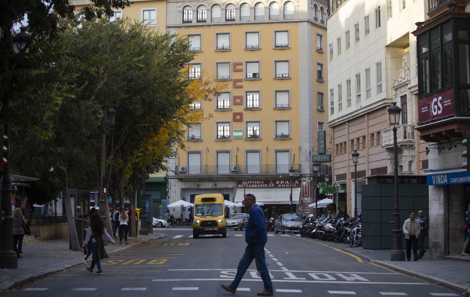 Varias personas en la Plaza del Duque con la fachada del antiguo edificio de Comisiones Obreras al fondo.