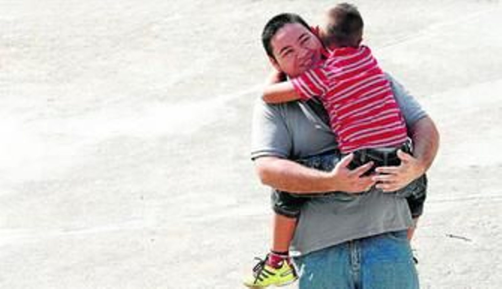 Juan Familiar abraza a su hijo, que va a cumplir siete años, en un parque en el municipio de Los Barrios el pasado jueves.