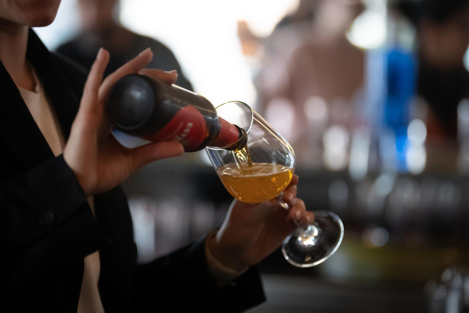 Una mujer vierte cerveza en una copa