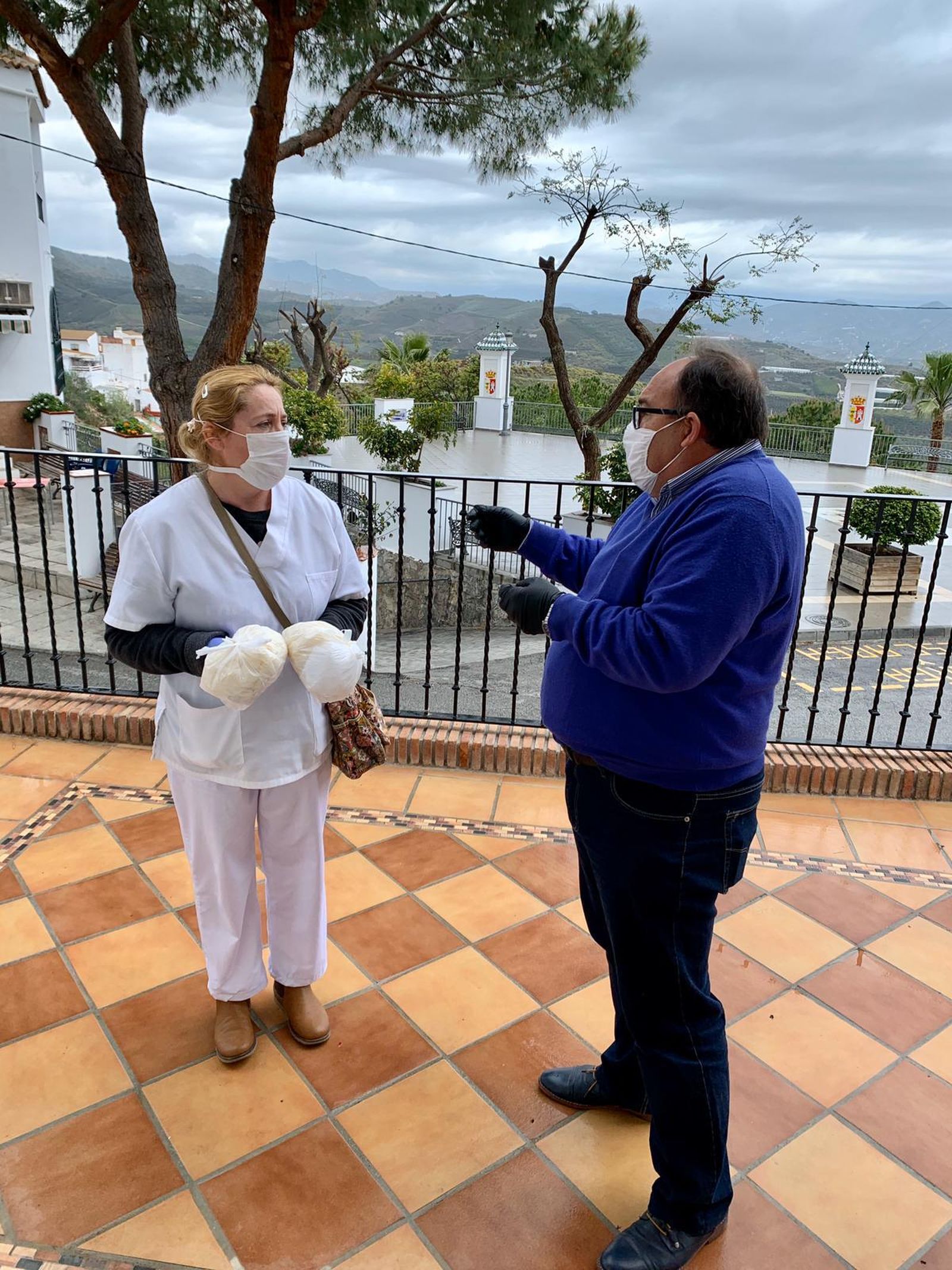 El regidor de Iznate, Gregorio Campos hablando con una vecina.