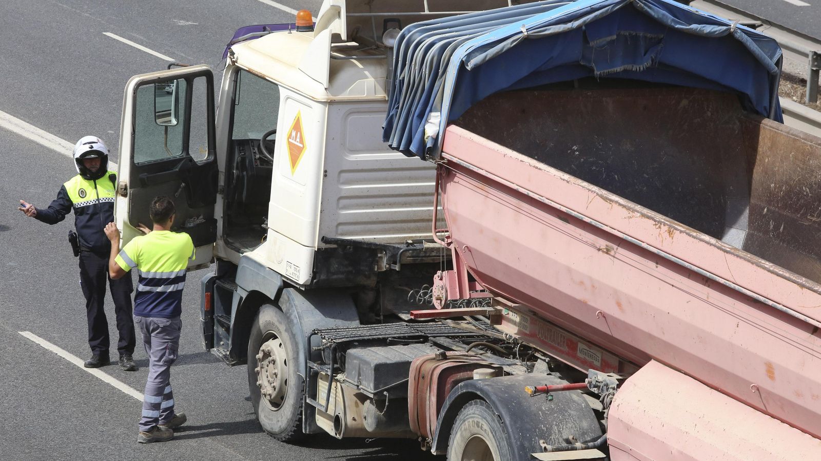 Agente dialoga con un camionero que secunda la huelga.