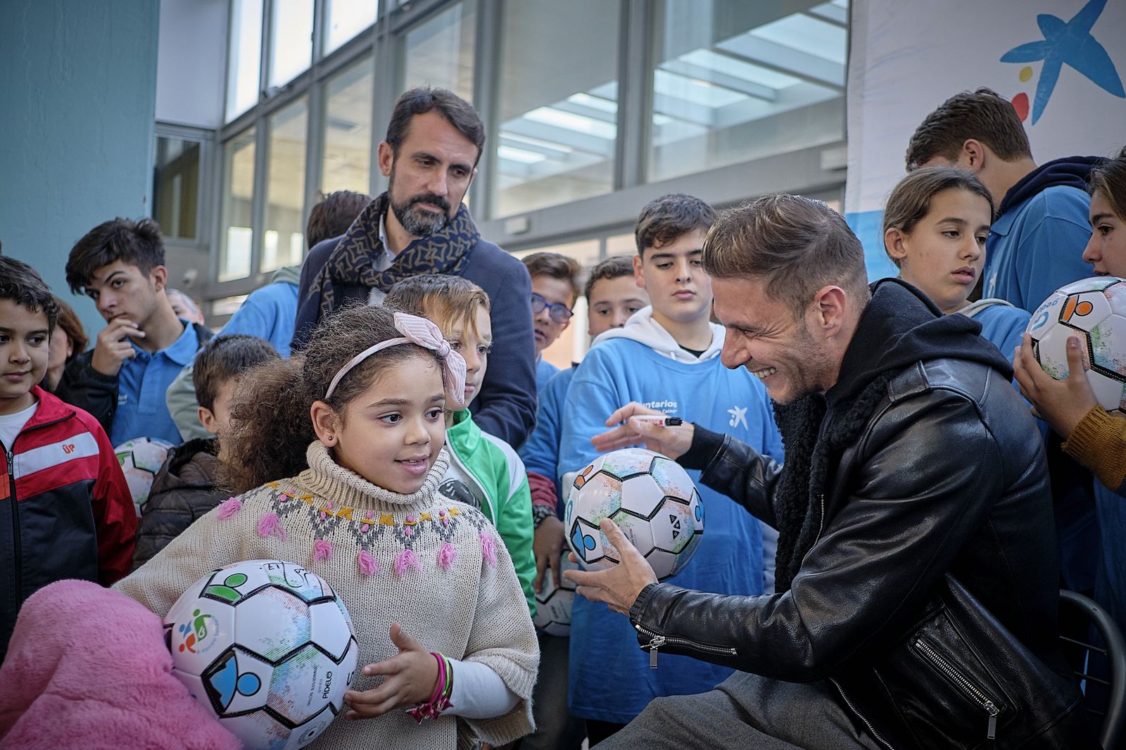 El bético Joaquín entrega balones firmados a 120 niños y niñas.