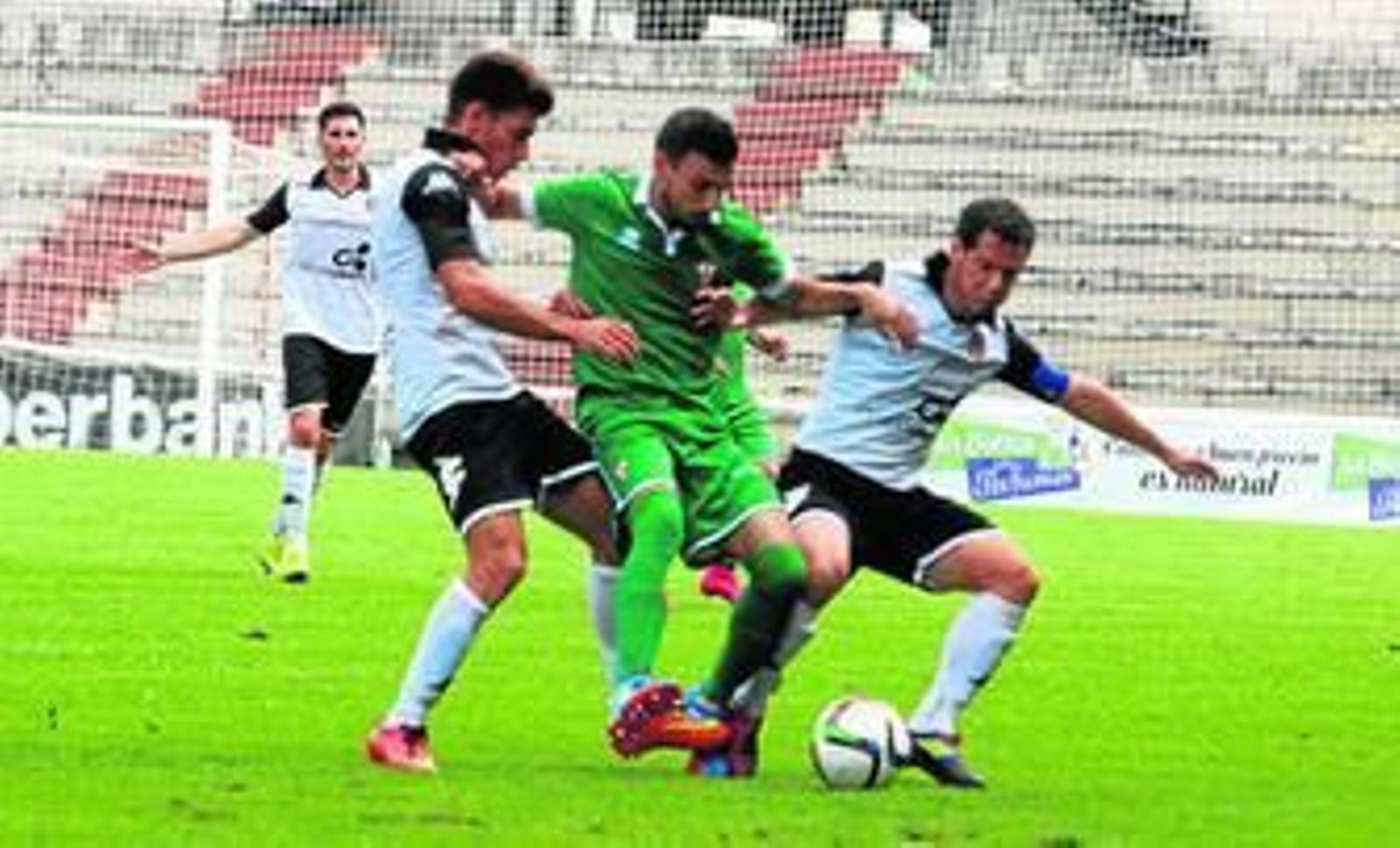 Melchor guerrea con dos jugadores rivales que intentan quitarle el esférico.