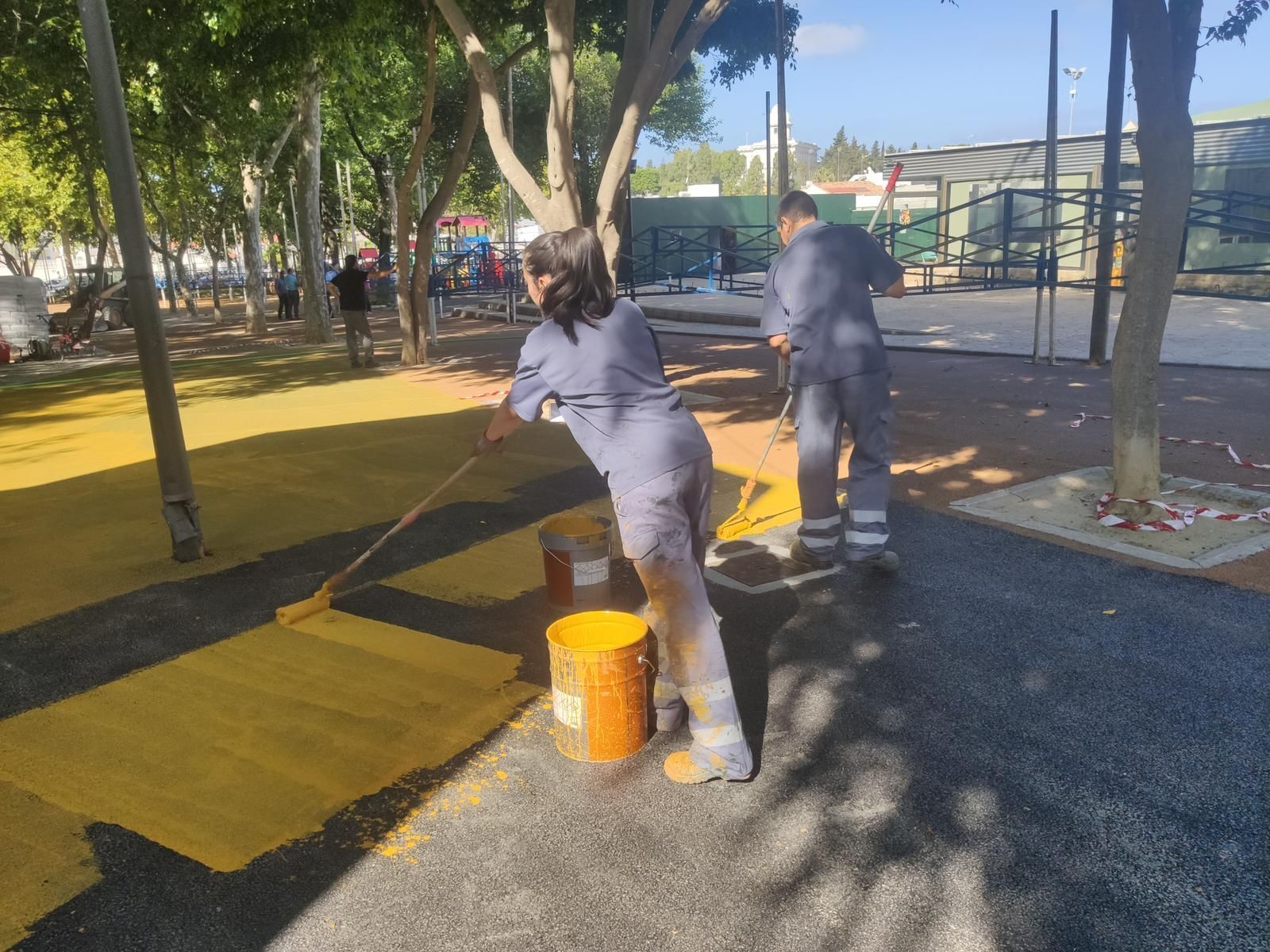 Trabajadores del plan de empleo juvenil pintan la superficie del Parque Almirante Laulhé para la Feria.