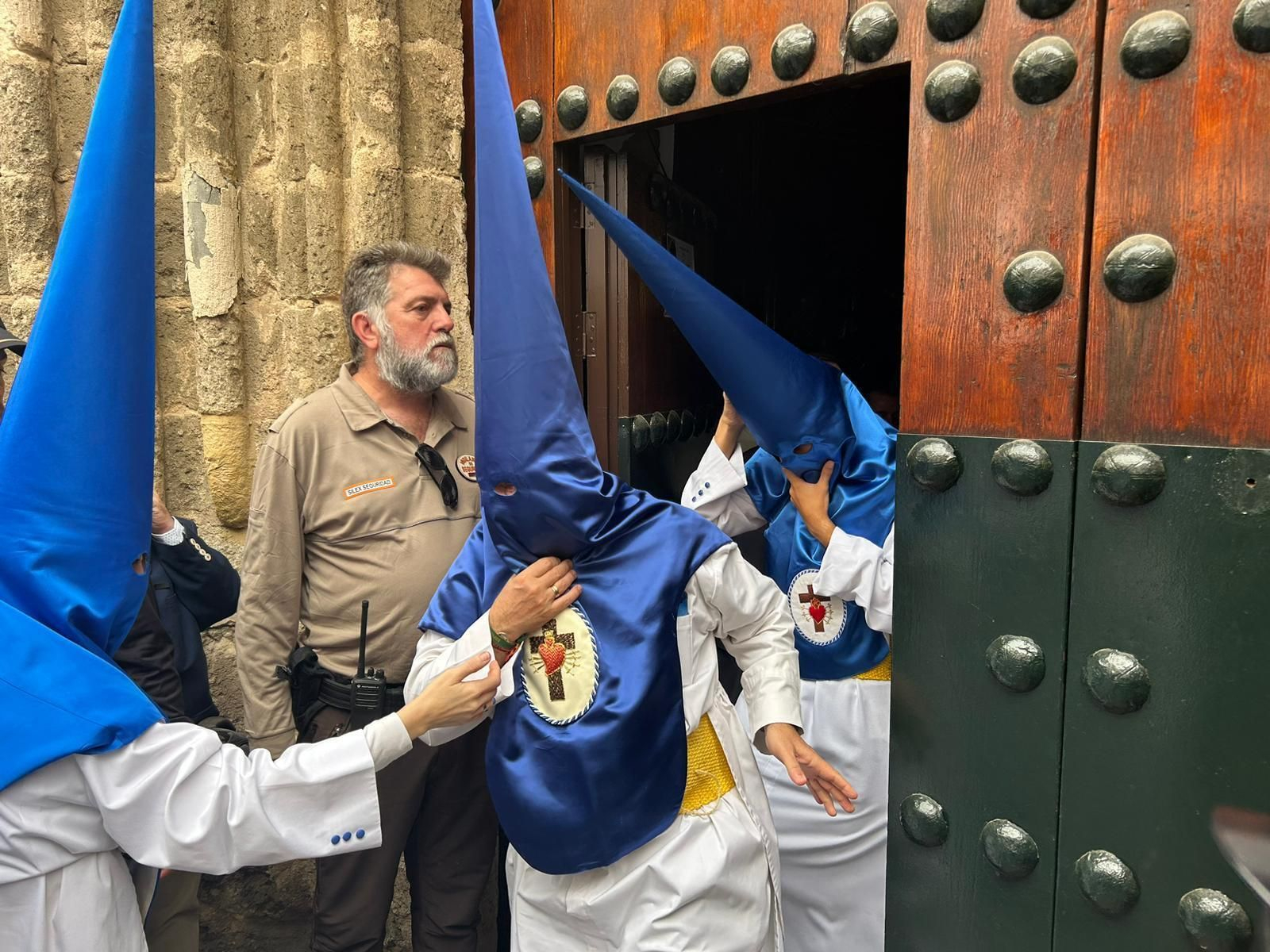 Los nazarenos de la HIniesta abandonan San Julián tras anularse su salida en el Domingo de Ramos de Sevilla 2024.