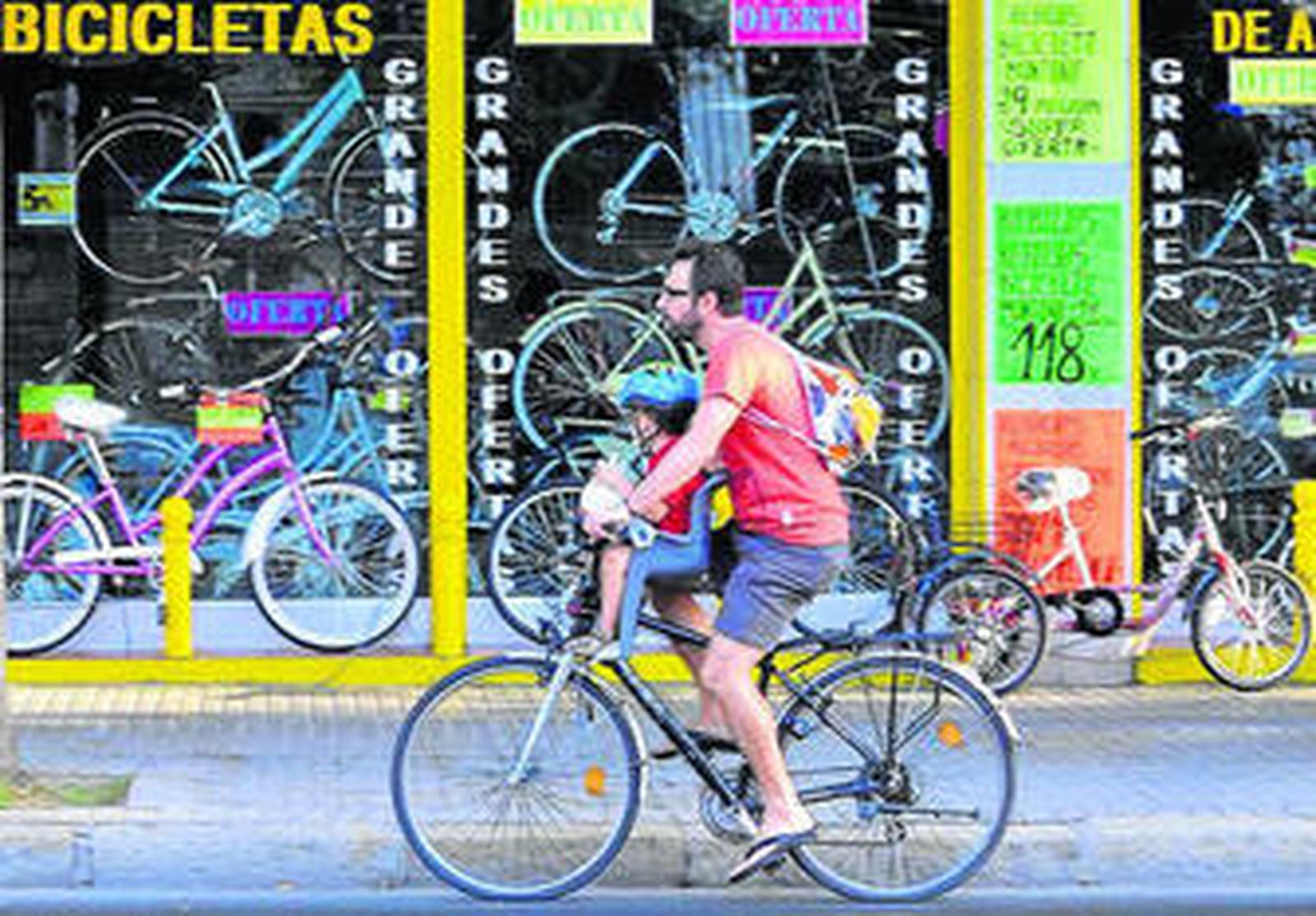 Un ciclista pasa por delante de una tienda de bicicletas.