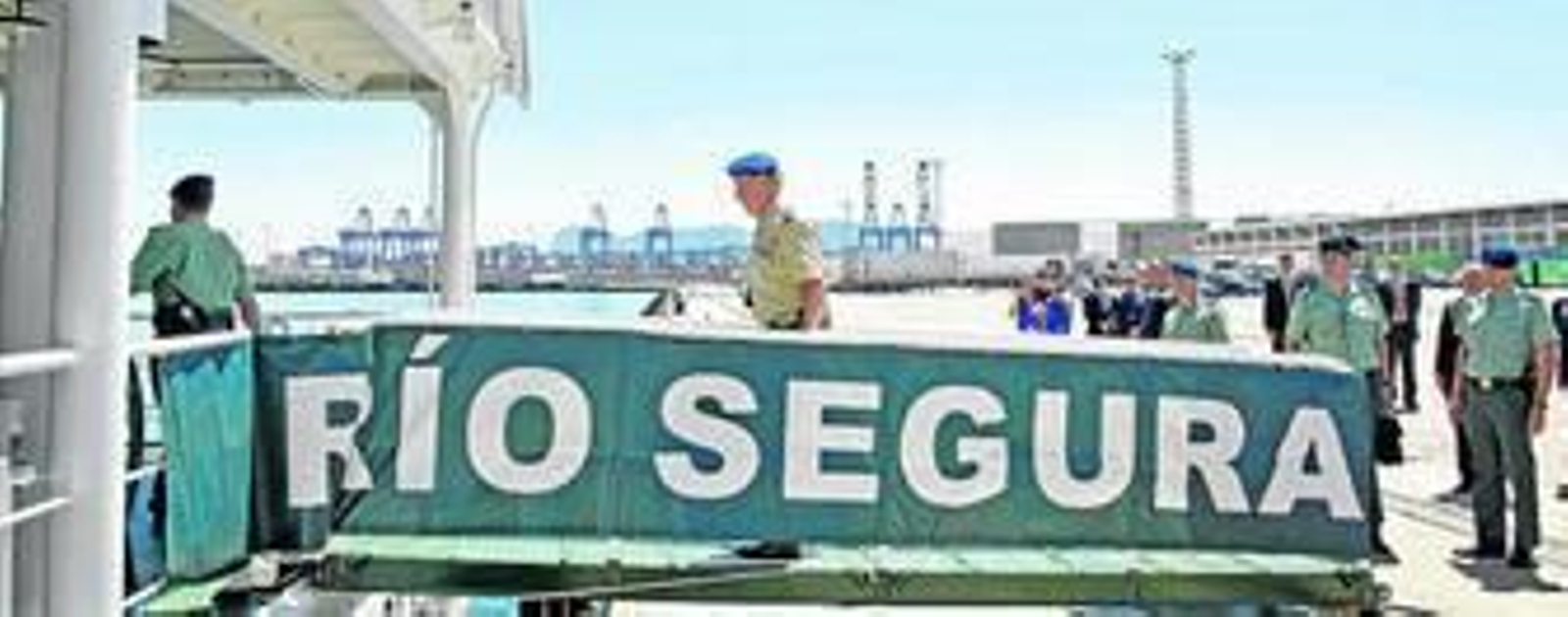 El Rey accede por una pasarela al buque `Río Segura', atracado en Isla Verde, con varias de las grúas del puerto de Algeciras al fondo, en la visita de 2012.
