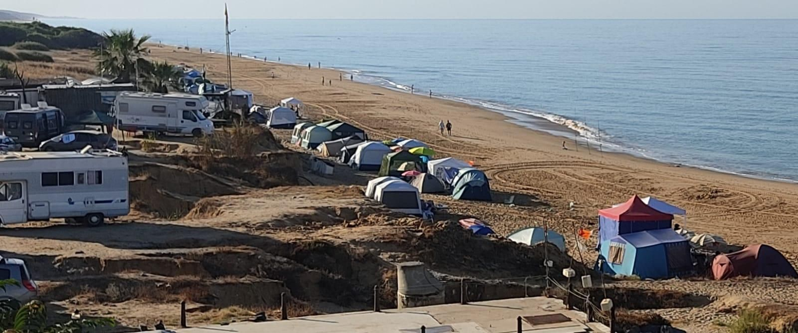 Algunas de las tiendas de campañas y carpas haciendo una kilométrica fila en primera línea de playa.
