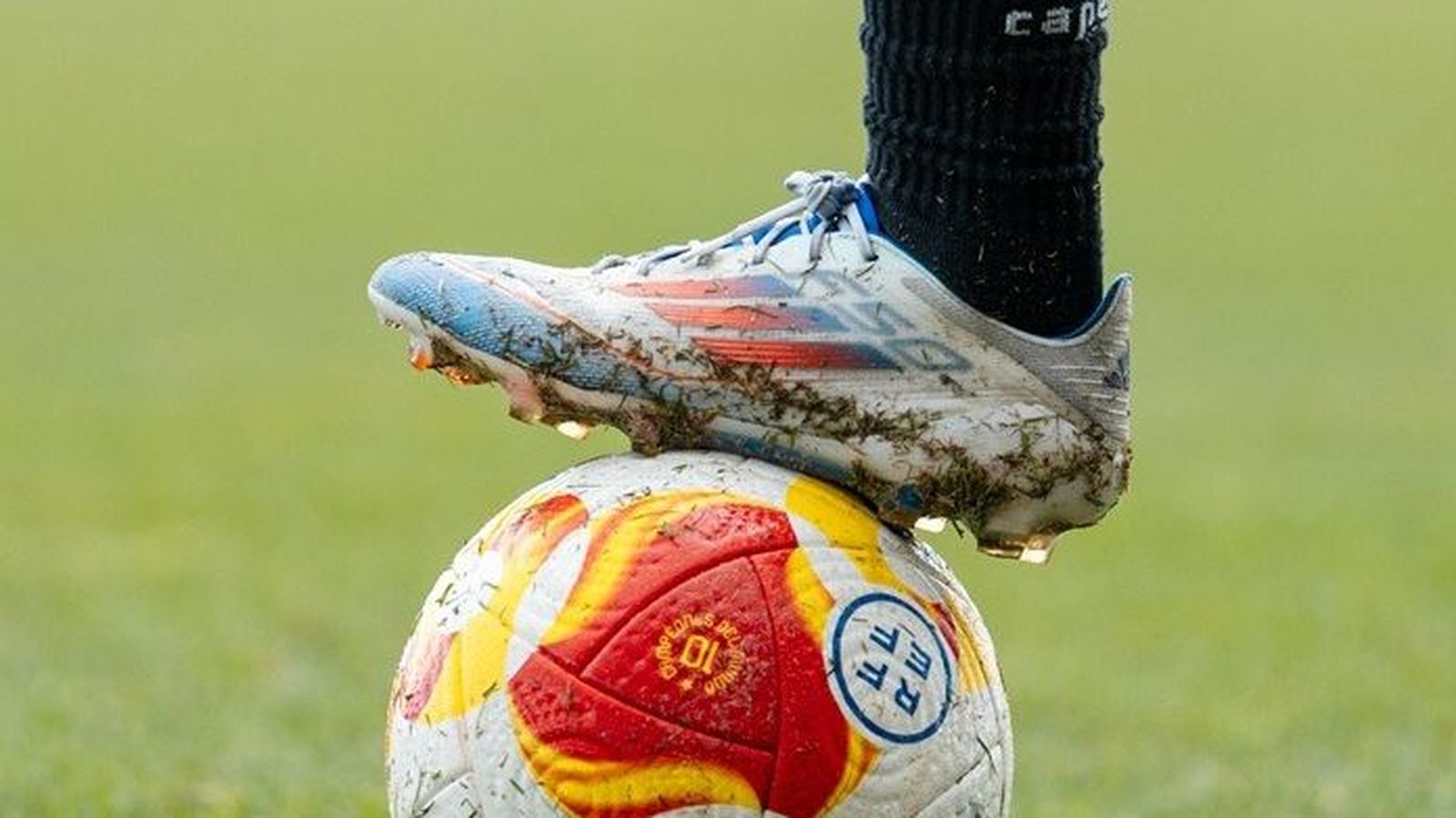 Detalle de un balón y una pierna de un jugador del Algeciras.